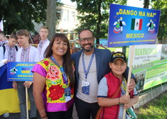 mężczyzna, kobieta i dziecko pozują do zdjęcia, dziecko trzma tabliczkę z napisem Mexico