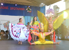 tańcerze w kolorowych strojach tańczą na scenie
