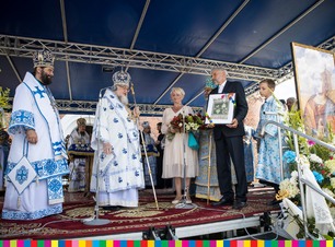 Wiesława Burnos i Sławomir Nazaruk przekazują kwiaty i makatkę zwierzchnikowi Cerkwi