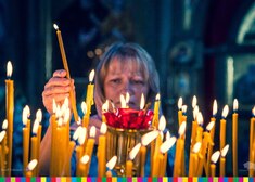 Kobieta zapala świeczki w cerkwi