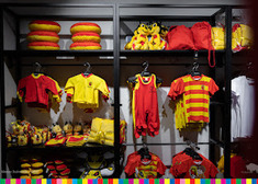 wnętrze sklepu Jagiellonii, na wieszakach wiszą ubrania w barwach żółto-czerwonych