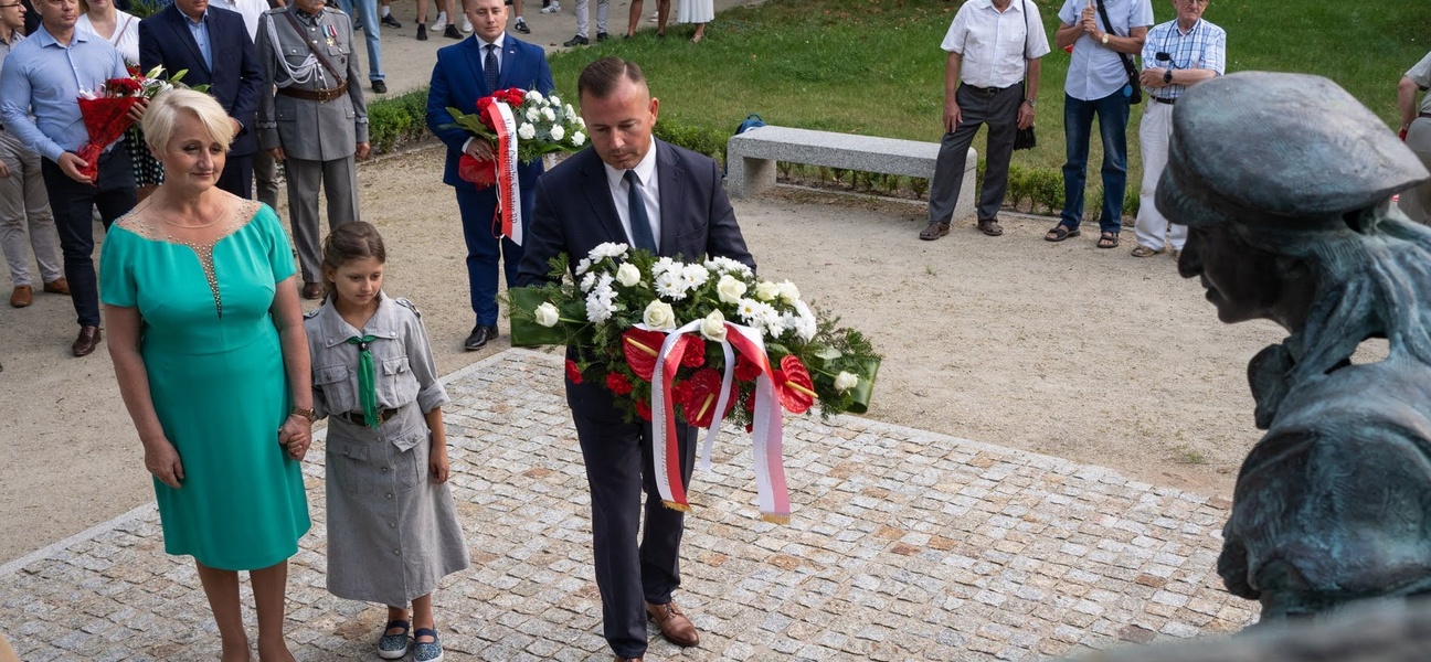 Członek zarządu, Wiesława Burnos wraz z uczestnikami składa kwiaty pod pomnikiem