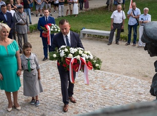 Członek zarządu, Wiesława Burnos wraz z uczestnikami składa kwiaty pod pomnikiem