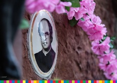 Fotografia nagrobna z wizerunkiem ks. Stanisława Suchowolca. Widoczne kwiaty