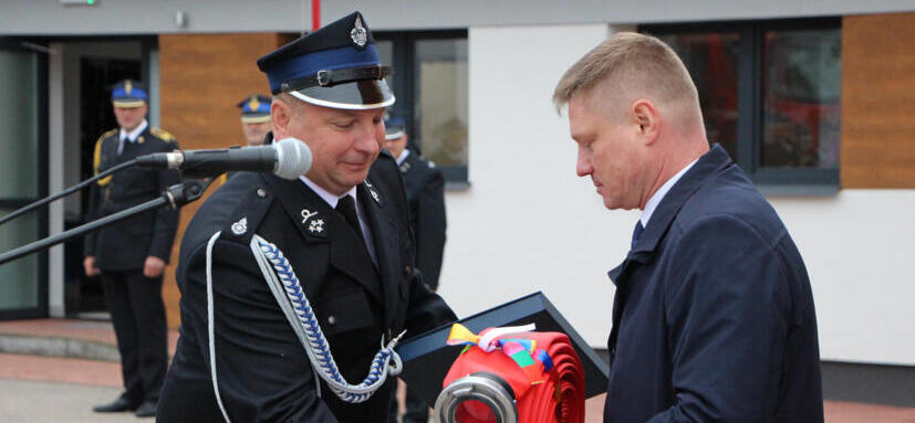 Marek Malinowski i strażak przed siedzibą OSP